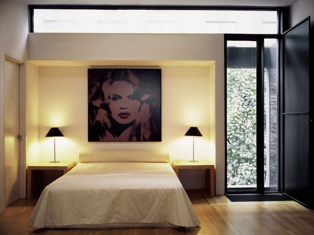 Photo of second modern designed bedroom with minimalist bed and painting on he wall