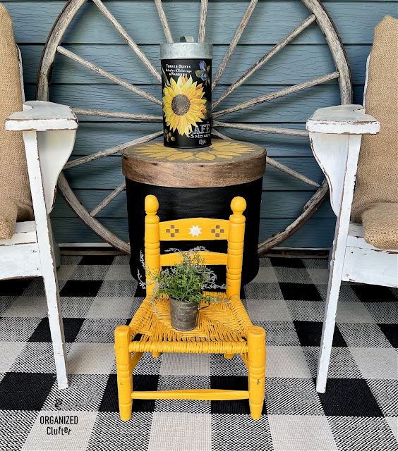 Photo of a sunflower cheese box side table, sunflower galvanized canister and mustard chair.