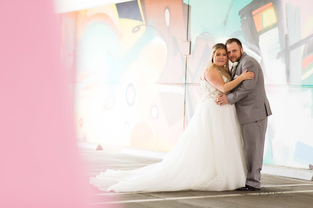 bride and groom on z belt lot rooftop in detroit posing by graffiti