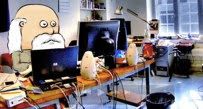 An upset cartoon Rip Van Winkle sitting at many computers