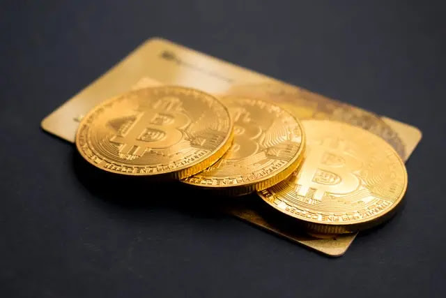 A photo of gold coins placed on top of an ATM or VISA Card