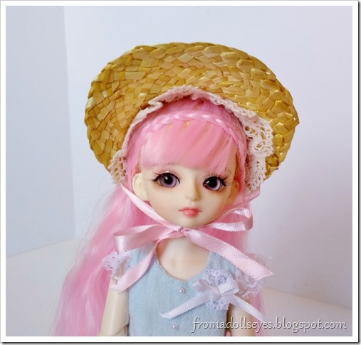 A small bjd with pink hair (Yuna) wear a half bonnet.  It looks so cute on her.