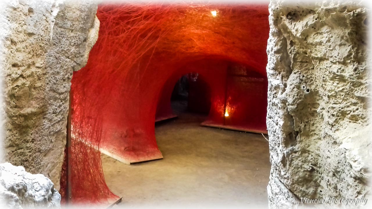 Artystyczna instalacja z czerwonej nitki znajdująca się w jaskini wzgórza Fabryka.