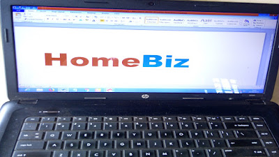 Red and blue HomeBiz sign on the screen of a black computer.