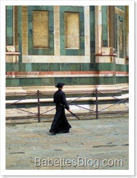 Priest walking beside Duomo in Florence, Italy