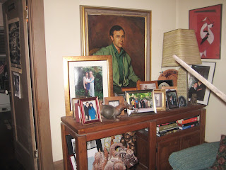 This is Floyd Salas’ living room, filled with sculptures, colorful pictures, portraits and memories. The portrait is of Floyd himself when he was young and family photos adorn the table.