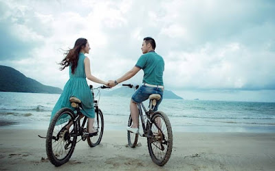 pareja andando en bicicleta de la mano