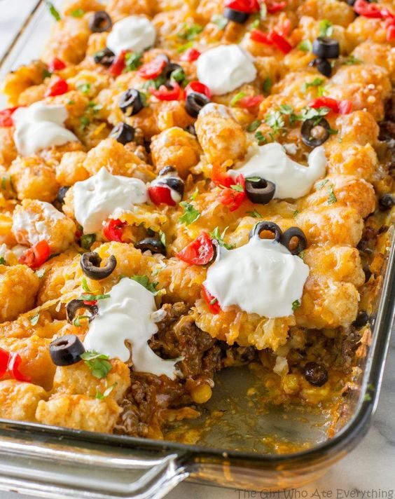 This Tater Taco Casserole is a Mexican mixture of taco meat, beans, corn, and cheese topped with tater tots and enchilada sauce.