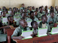 Photo of a classroom of students using the OLPC laptop