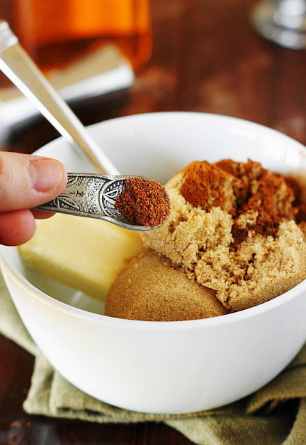 Measuring Spoon of Ground Nutmeg Being Added to Bowl of Hot Buttered Rum Ingredients Image