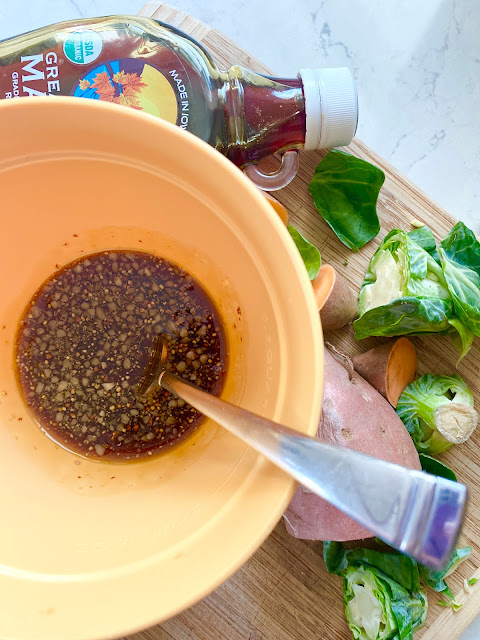 Yellow bowl and spoon with prepared marinade next to chopped vegetables.