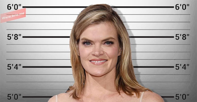 Missi Pyle posing in front of a height chart background