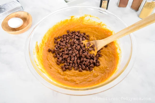 adding chocolate chips to pumpkin muffin batter