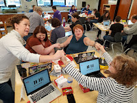 a group of six teacher holding hands to create a circuit and play piano