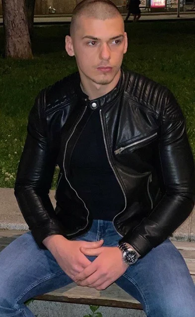 Bald dude sitting wearing leather jacket