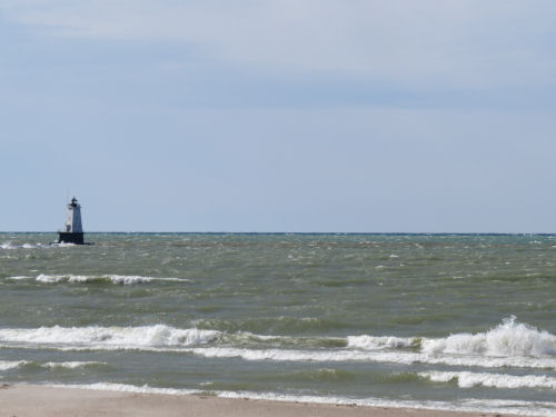 Lake Michigan with green waves and Ludington Lighthouse