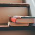 Old books stacked on top of a ladder