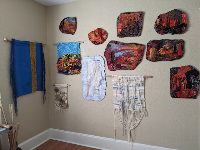 Several fiber artworks on the walls in the studio