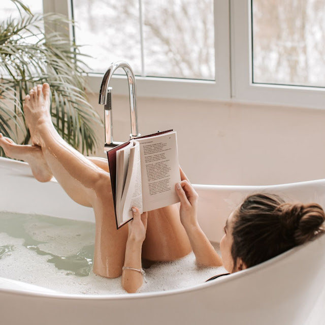 Frau liest ein Buch in der Badewanne