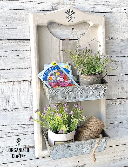 Photo of wall bins made from a wooden calendar holder and loaf pans.