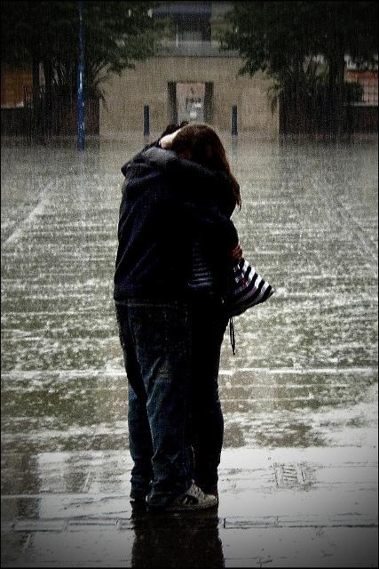 young couple kissing in rain. house couple kissing in rain