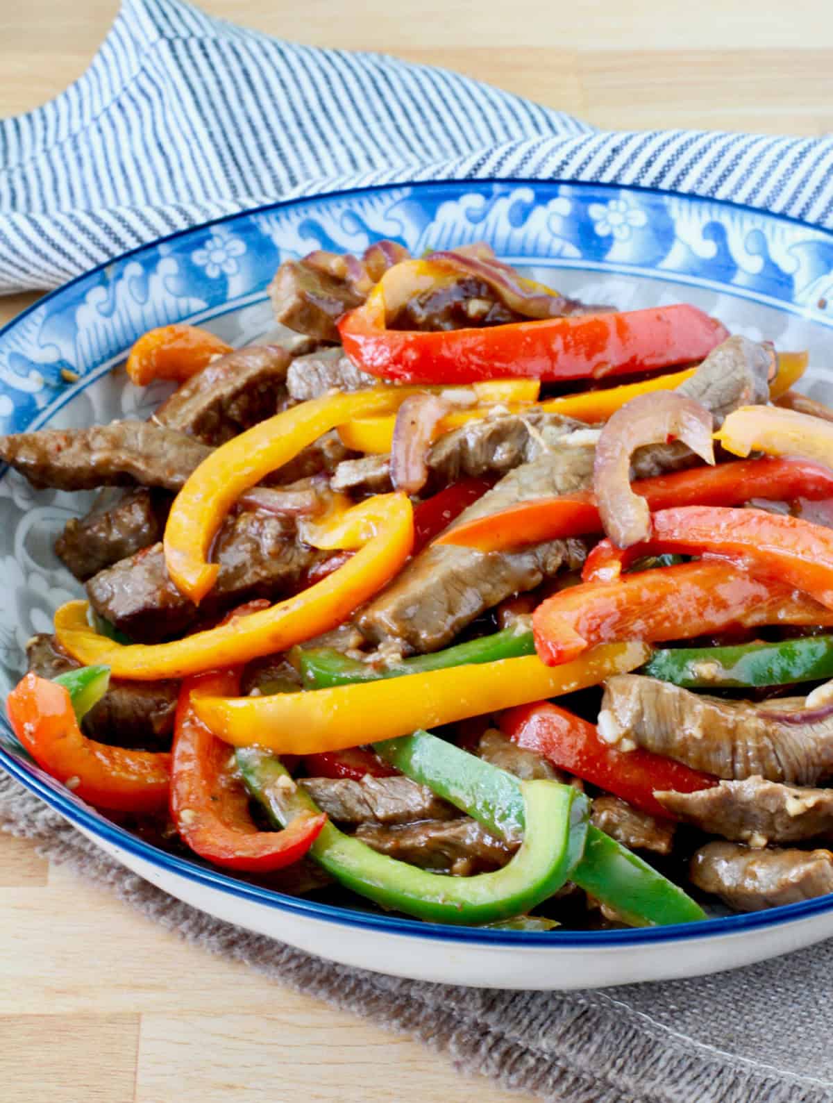 Hot Pepper Beef Stir-Fry in a blue rimmed Asian style bowl.