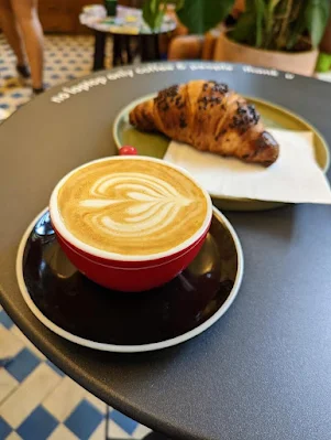 Cappuccino and chocolate croissant at Buna Specialty Coffee Shop in Lisbon