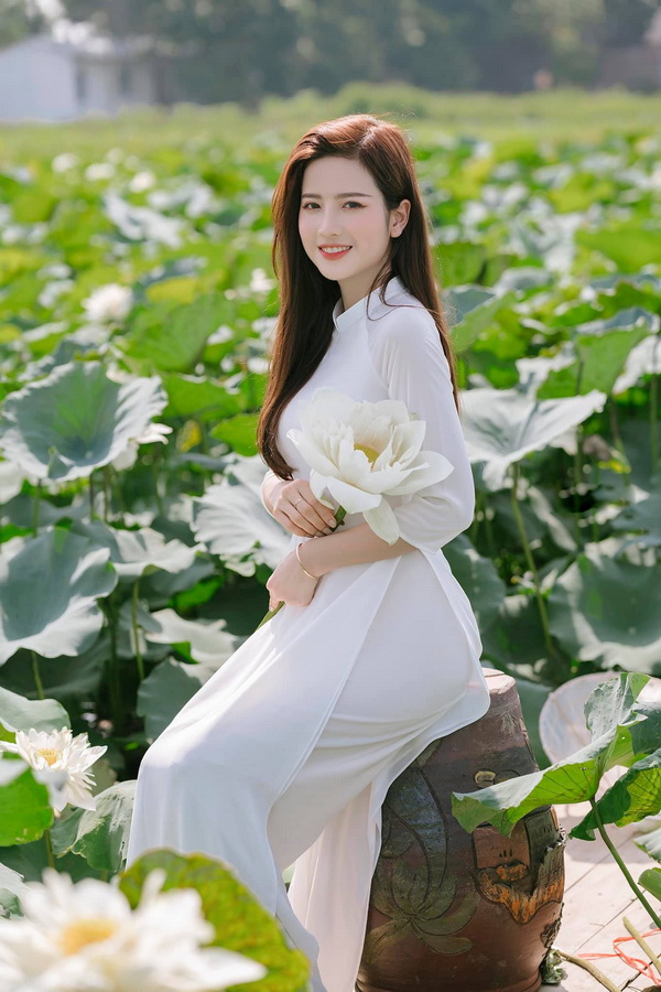 Thiếu nữ ngồi áo dài trắng ôm hoa sen