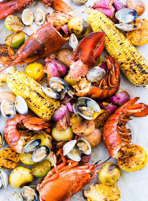 This New England clambake, made with clams, lobster, Old Bay, sweet corn, and potatoes, is a summer classic. Easy to make at home.