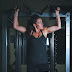 Woman hanging on gym equipment on focus