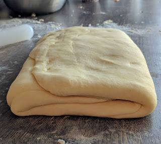 pâte feuilletée posée sur un plan de travail fariné pour la préparation d'un mille feuilles