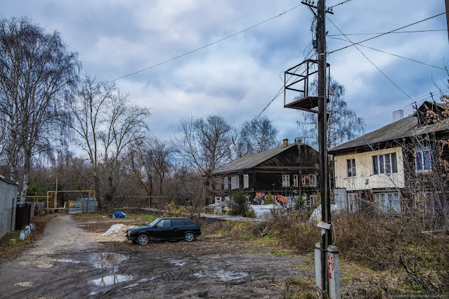 Машина припаркована в грязи у жилого дома