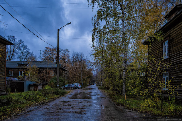 Улица в лужах я ямах среди деревянных домов