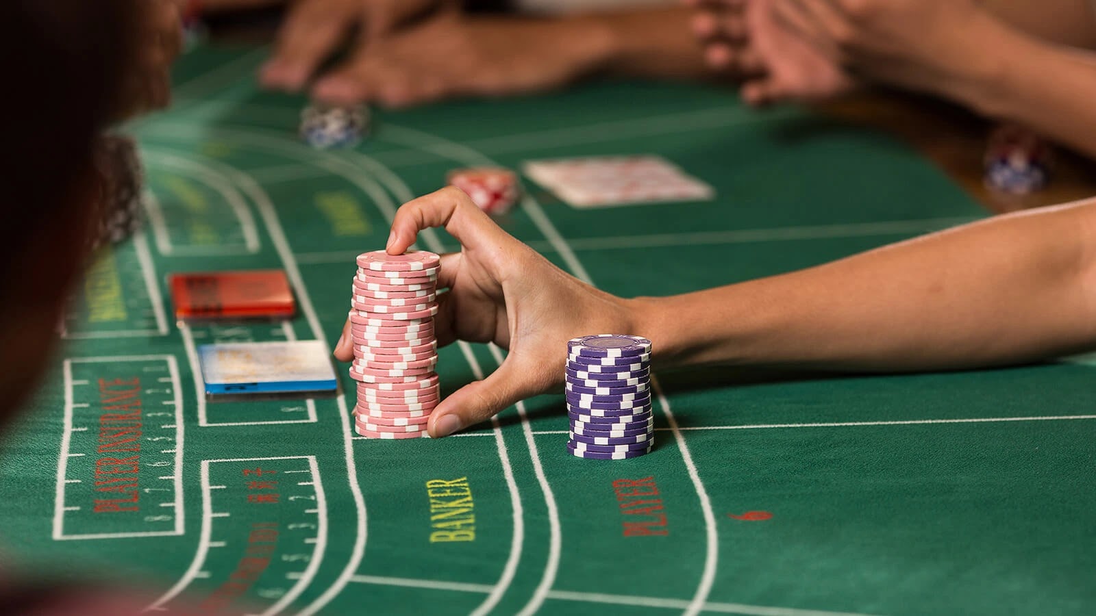 Baccarat Player Placing Bets on the Casino Table