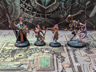 The Dread Pageant warband painted in a pink/purple colour scheme with a mix of skin colours