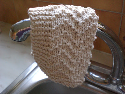 Knitted dishcloth on the tap