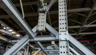 A detailed close-up of a complex metal structure showcasing interconnected beams and supports, highlighting the interplay of tension and compression, with a focus on the precision of engineering joints and welds, surrounded by an industrial workspace setting.