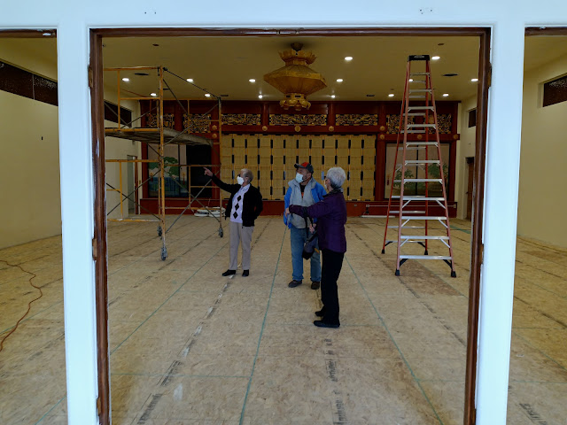 People standing in main hall of Buddhist temple under construction