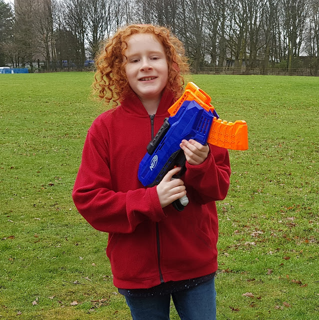 Boy holding Nerf Rukkus ICS-8 Nerf N-Strike Elite on parkland