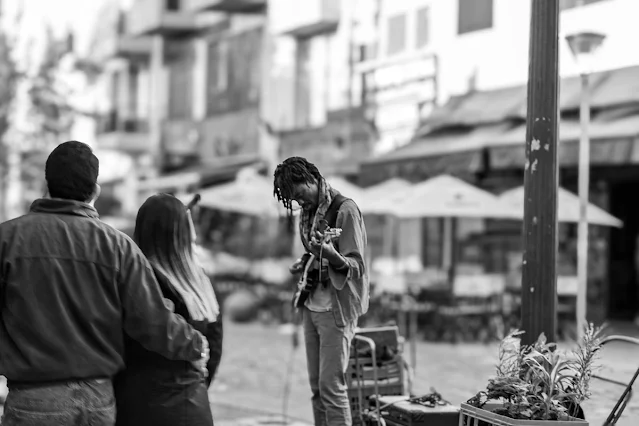 Joven guitarrista tocando en la Recoleta para los visitantes.