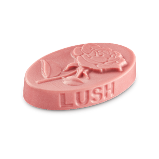 A photo of a cyldirncual neon pink oval shaped massage bar with a rose engraved on the top of it on a bright background