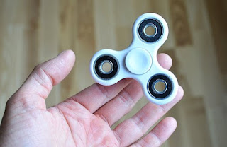 saat ini ada mainan yang sedang ngetren bernama fidget spinner Fungsi Fidget Spinner Sebagai Sarana Hiburan dan kesehatan