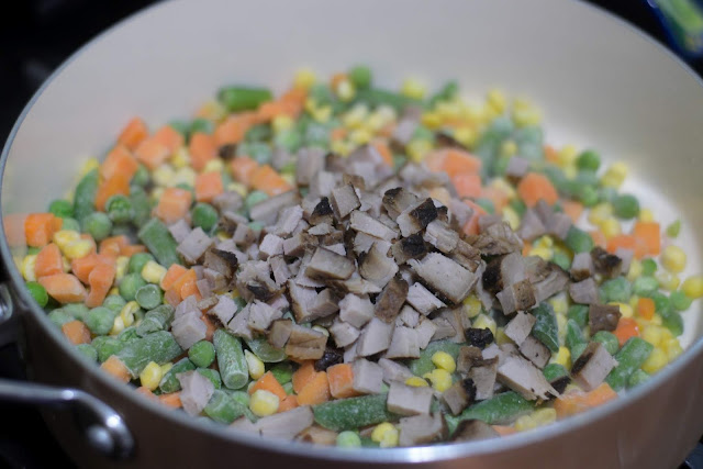 The diced pork chop and vegetables in the pan.