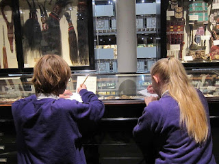 Photograph of two students drawing in the Pitt Rivers Museum