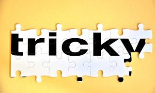 Image of puzzle pieces put together to spell the word TRICKY