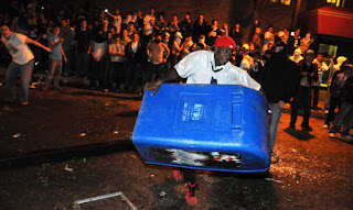 A Penn State fan ironically tries to steal a newspaper box.  Ironic because he doesn't know how to read