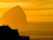 Haystack Rock, a wellknown Cannon Beach landmark, appears through the . (canon beach sunset )