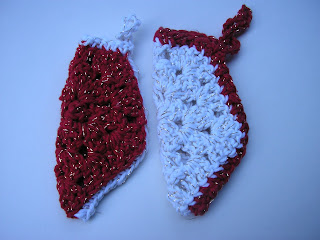Two granny square Christmas stockings, one red with white edging, the other white with red edging.
