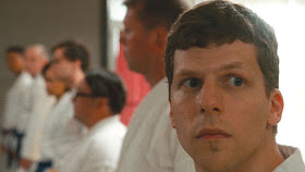 jesse eisenberg looks worried in a dojo