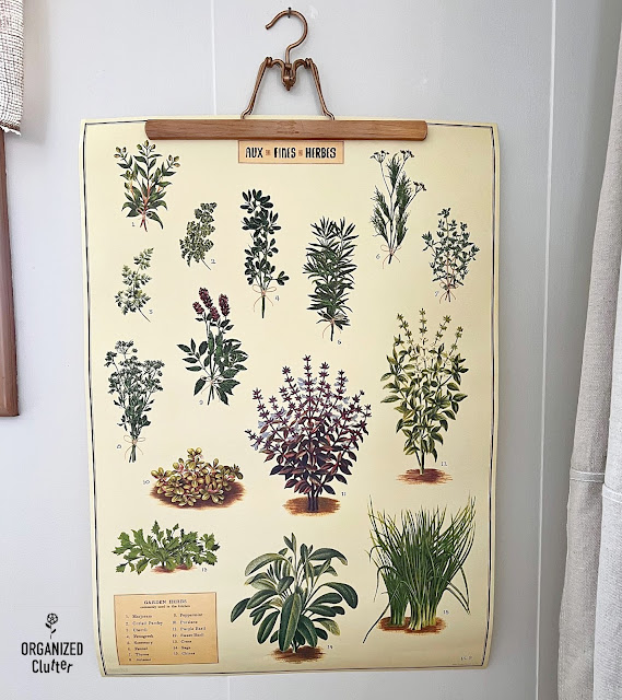 Photo of an herb poster hanging on an upcycled skirt/trouser hanger.